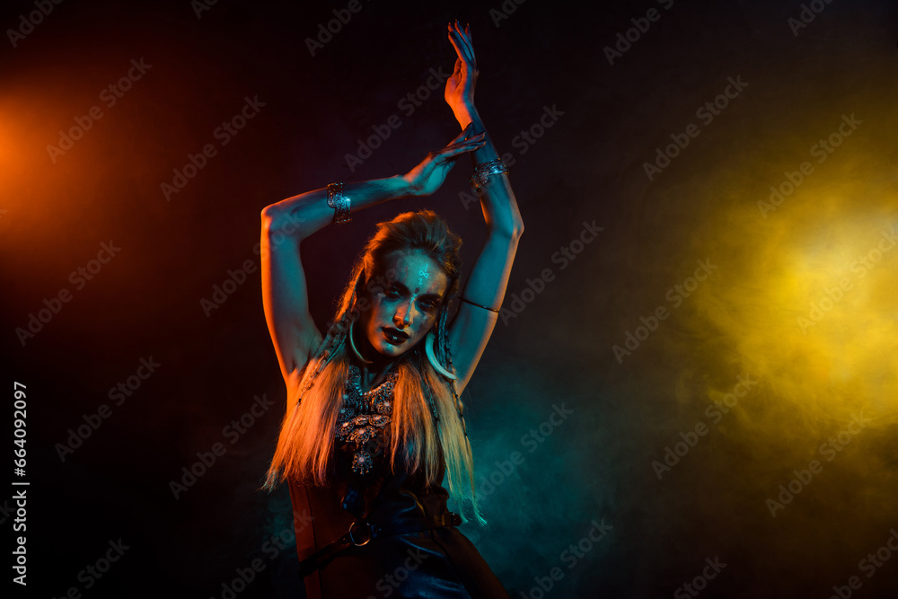 Photo of attractive wild mysterious lady wear viking clothes enjoying ritual dance isolated orange smoke background