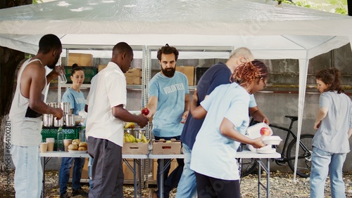 Photos At humanitarian food drive, an elderly Caucasian guy with crutches is aided by a nice black woman