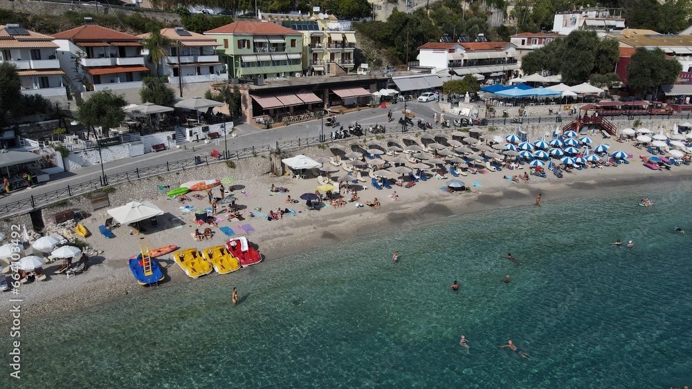 Fototapeta premium Aerial drone view parga greece, beach crowded with tourists in vacation on summer in famous greek caribbean parga town epirus preveza