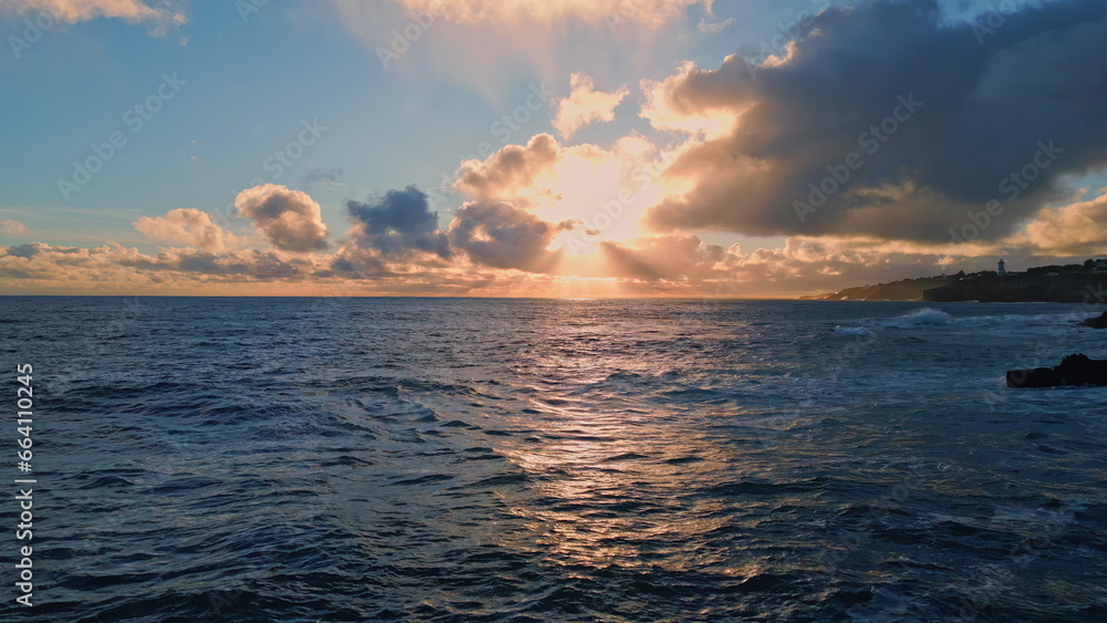 Fototapeta premium Amazing bright marine sunset over ocean surface reflecting evening light aerial.