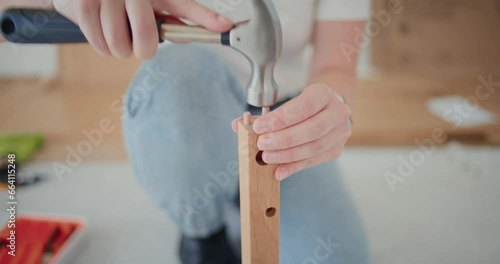 Female worker installing screw on wood photo