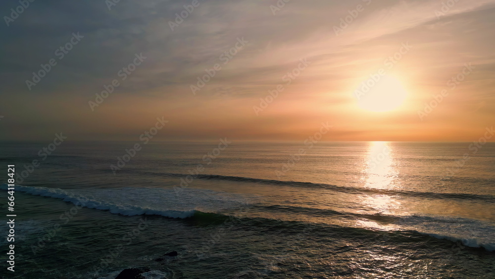 Sunrise sea rippling water beach aerial view. Dawn sky over dark serene ocean