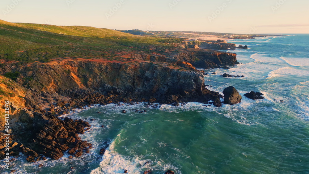 Ocean swell grassy cliffs landscape aerial view. Foaming waves rolling coastline