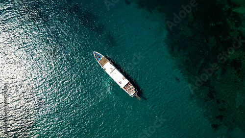 Aerial view of diagonally positioned ship in blue water
