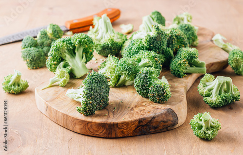 Chopped broccoli on a wooden cutting board on wooden background