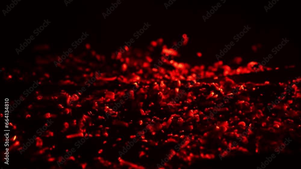 Shimmering red light appearing in the smoldering embers. Campfire burnt out and the hot pieces of charcoal flashing. Close up. Black backdrop. Shimmering red light appearing in the smoldering embers. Campfire burnt out and the hot pieces of charcoal flashing. Close up. Black backdrop.