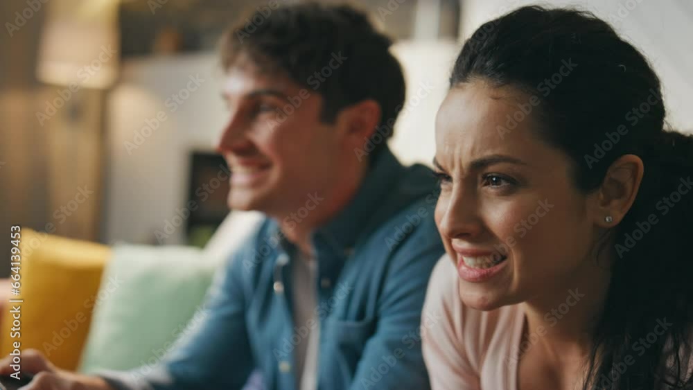 Couple playing video game sitting couch close up. Woman focused on competition.