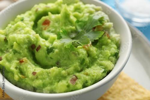 Delicious guacamole with parsley on table, closeup