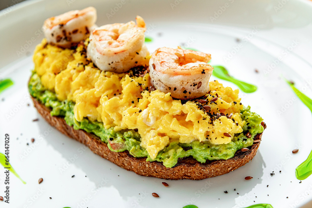 Scrambled on toast with guacamole, shrimp and olives Scrambled on toast with guacamole, shrimp and olives