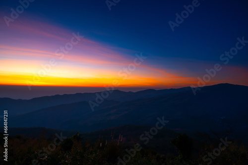 Aerial view sunset , sunrise over dark mountain with fog over the ground.The early evening sun illuminates the mountains and valleys.Dawn the first appearance of light in the sky before sunrise.