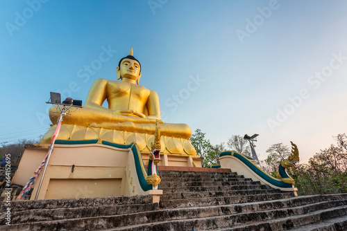 Large hilltop Golden Buddha statue at Wat Phousalao,overlooking Mekong River at sunset,Pakse,Laos. photo