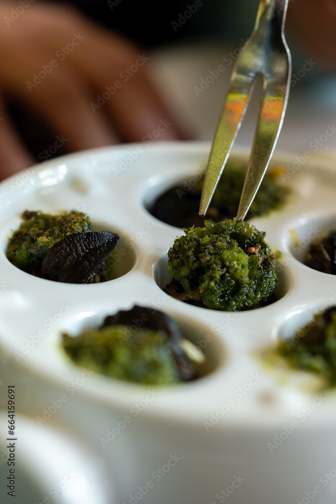 Starter dish in traditional restaurants on Burgundy, snails cooked with butter, garlic and herbs, France Starter dish in traditional restaurants on Burgundy, snails cooked with butter, garlic and herbs, France