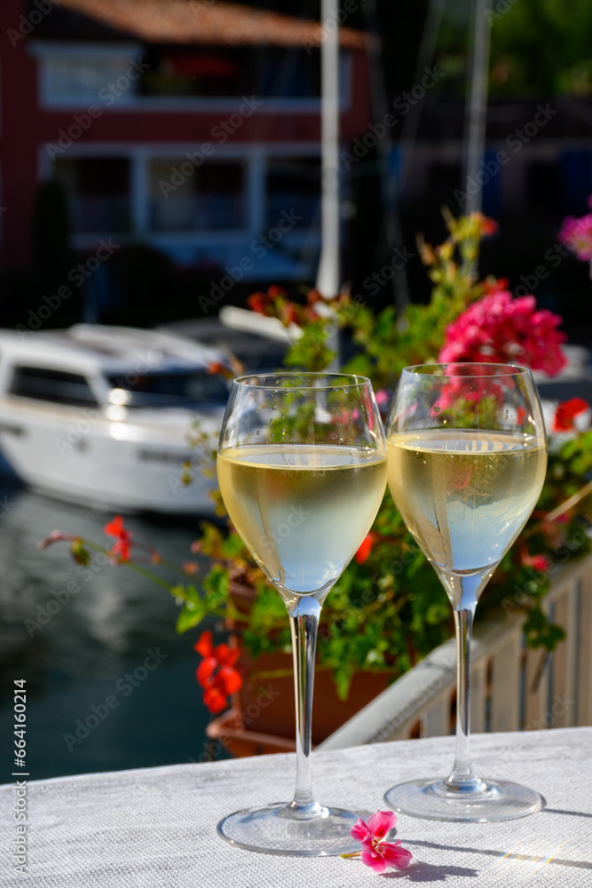Glasses of cold white Cote de Provence wine in yacht harbour of Port Grimaud, summer vacation on French Riviera in Provence, France Glasses of cold white Cote de Provence wine in yacht harbour of Port Grimaud, summer vacation on French Riviera in Provence, France