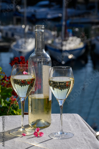 Glasses of cold white Cote de Provence wine in yacht harbour of Port Grimaud, summer vacation on French Riviera in Provence, France