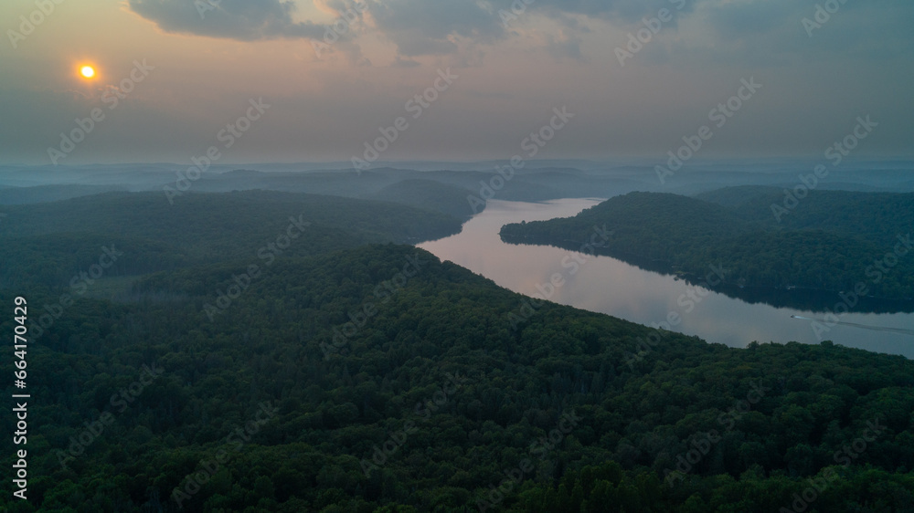 An aerial view of a boat curving around a lake in the country during sunset An aerial view of a boat curving around a lake in the country during sunset