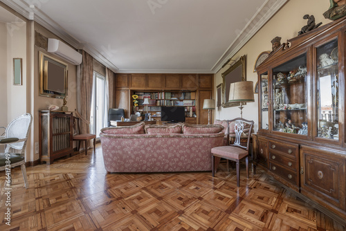 Apartment furnished in vintage style with lots of wood, hardwood parquet floors and sofas with patterned upholstery