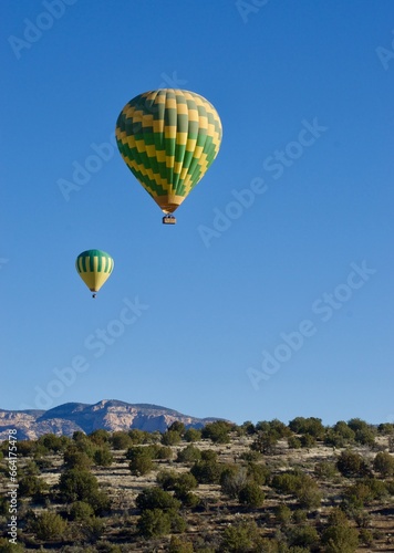 two hot air balloons in the sky one the Arizona desert