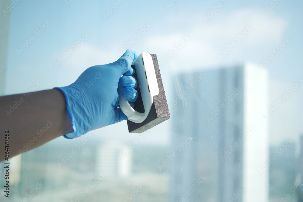  person hand in gloves cleaning window glass  - obrazy, fototapety, plakaty 