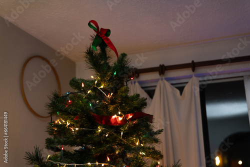 árbol de navidad con moño en la punta, sin estrella.