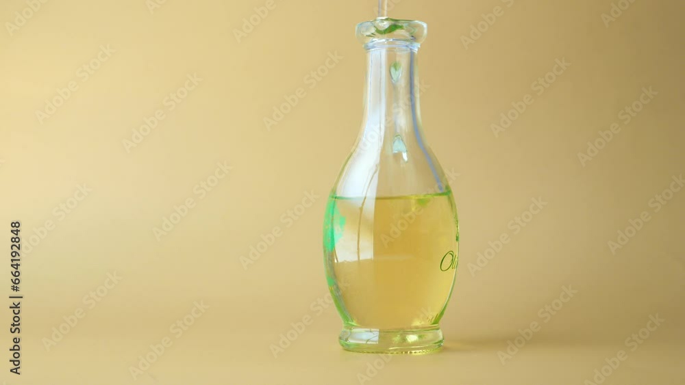 pouring olive oil in a jar on color background pouring olive oil in a jar on color background