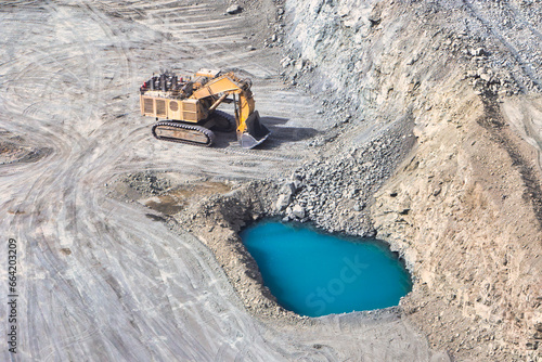 open pit diamond mine, Surface mining hydraulic excavator dinging in the pit, surface water infiltration
