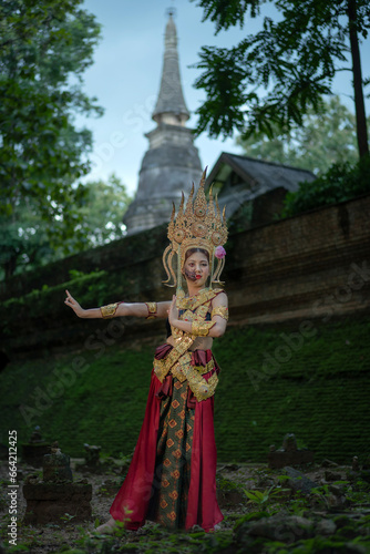 Pretty Asian woman wearing an ancient Traditional Khmer Cambodian Apsara dress costume shows the ghost a typical fairy Apsara. photo