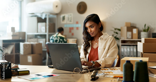 Fashion, woman and reading on laptop in office for research, feedback and supply chain for business. Indian, person and planning on pc for logistics, stock administration or package distribution data