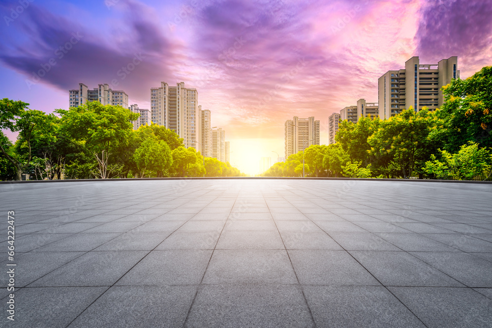 Square ground and city buildings background at sunset