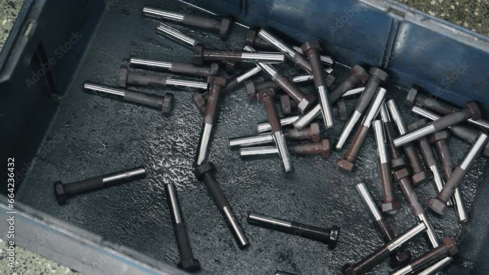 Production of bolts. Threaded bolts fall from above Production of bolts. Threaded bolts fall from above