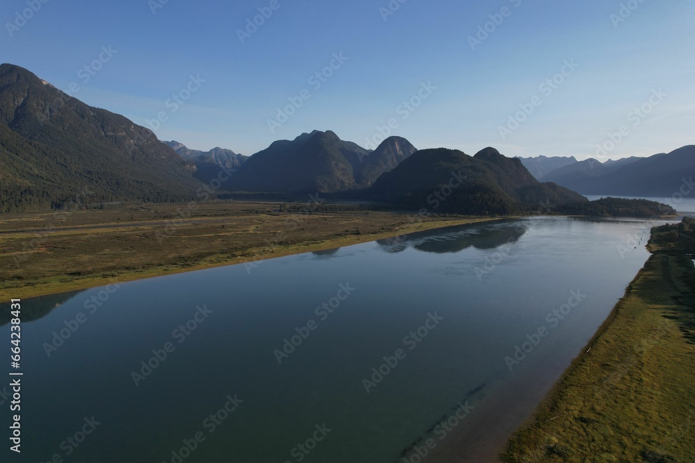 Aerial view of a tranquil lake surrounded by the mountains on a sunny day