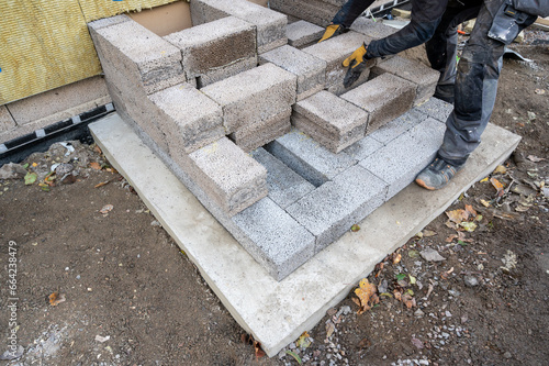 Worker building steps to entrance with light weight cinder blocks photo