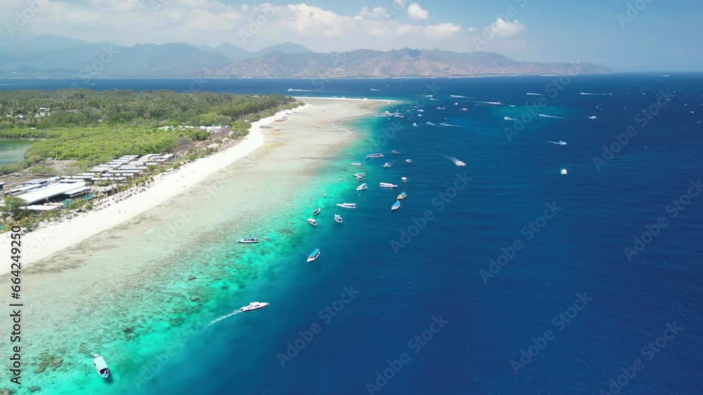 Aerial panorama view of the beach at Gili Meno Island, Indonesia, in sunny weather and with plenty of boats in the crystal blue water Aerial panorama view of the beach at Gili Meno Island, Indonesia, in sunny weather and with plenty of boats in the crystal blue water