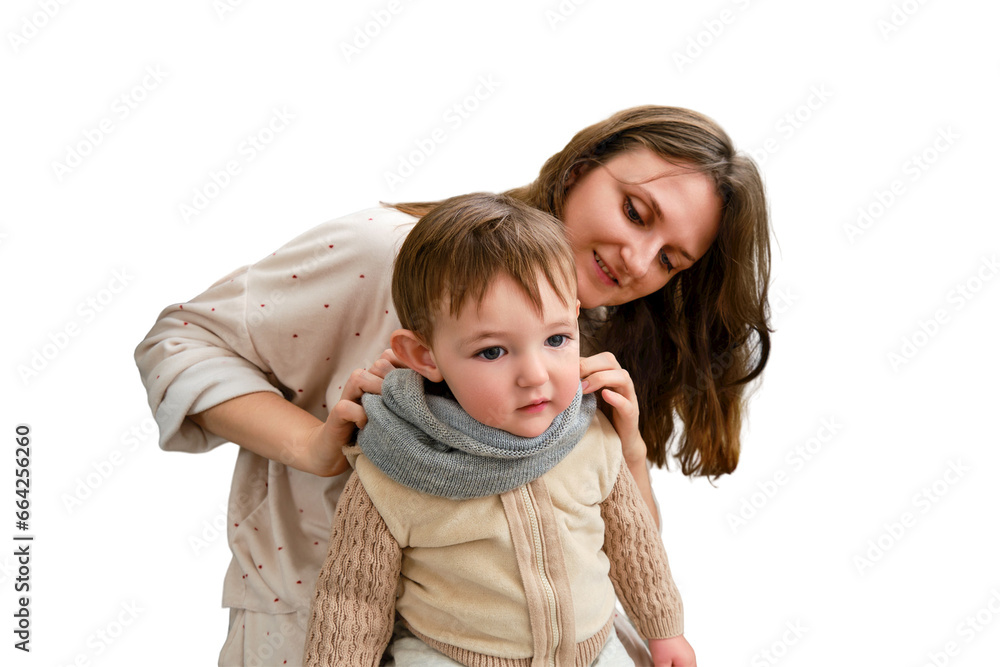 Mother puts a warm scarf on the toddler baby, isolated on a white background. Woman mom dressing warm clothes on child for winter walk in cold weather. Kid aged one year and three months