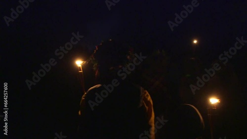 hand held medium shot of people walking with lighted torches on the night of the solstice