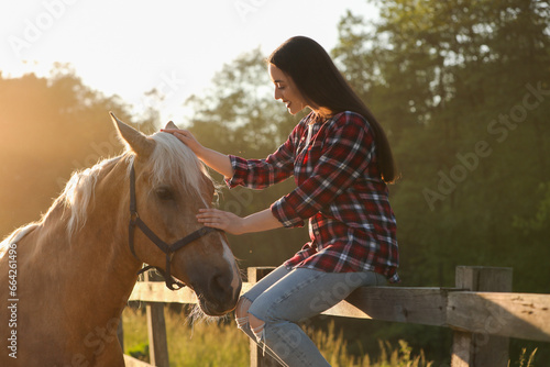 Beautiful woman with adorable horse outdoors. Lovely domesticated pet © New Africa