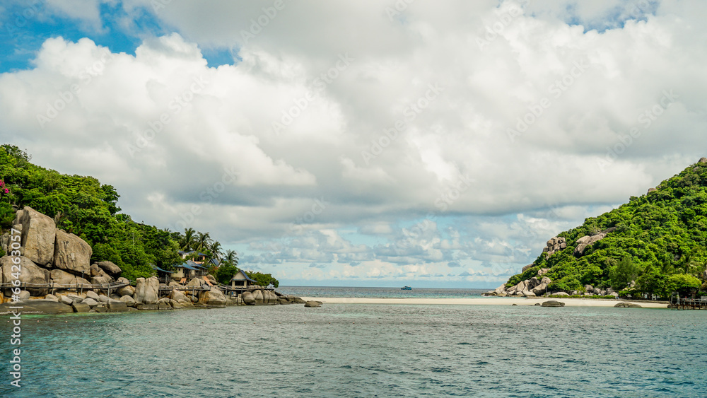 Fototapeta premium Scenic view tropical paradise with peaceful resort, rocky coastline, clear turquoise sea with coral reef against cloud sky. Koh Nangyuan Near Koh Tao Island, Thailand.