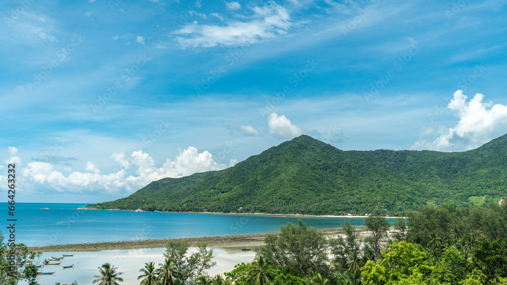 Panoramic view of a tropical beach, calm blue ocean, lush green rainforest, Chalokum beach on Koh Phangan coastline island, Thailand, beautiful summer day.