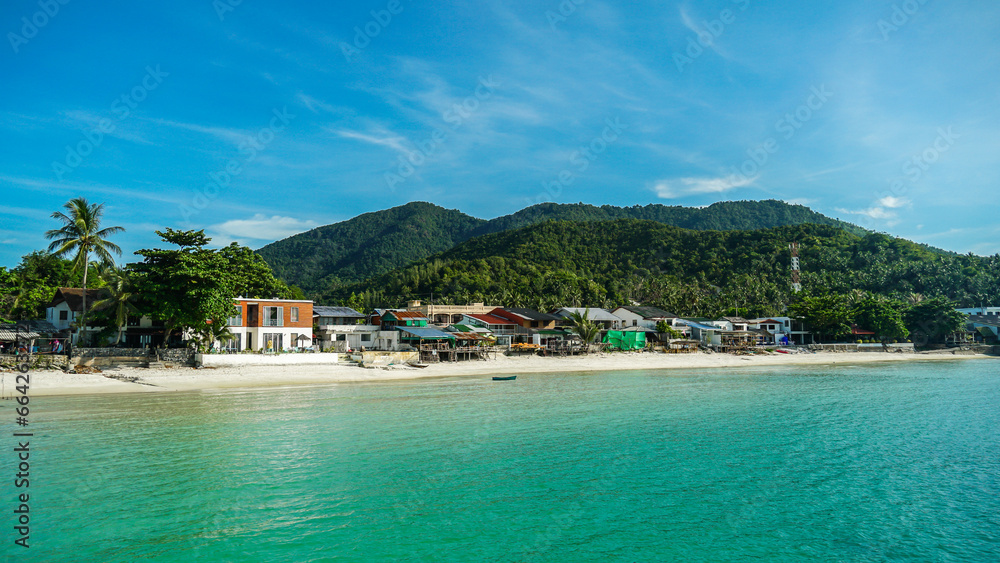 Panoramic view of a tropical beach, calm blue ocean, lush green rainforest, Chalokum beach on Koh Phangan coastline island, Thailand, beautiful summer day. Panoramic view of a tropical beach, calm blue ocean, lush green rainforest, Chalokum beach on Koh Phangan coastline island, Thailand, beautiful summer day.