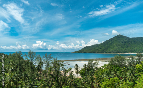 Panoramic view of a tropical beach, calm blue ocean, lush green rainforest, Chalokum beach on Koh Phangan coastline island, Thailand, beautiful summer day. © SandyHappy