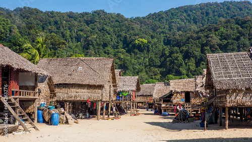 Traditional long-tail boats and houses of Morkan tribe Village or Sea Gypsies and tropical waters of Surin Islands. Fisherman village landscape of Ko Surin Marine National Park. photo