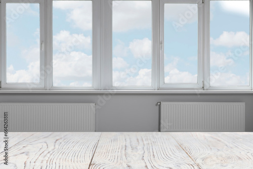 Empty white wooden table against window indoors. Space for design