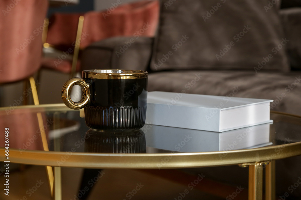 Tea cup and book on the coffee table in the living room