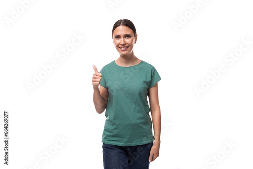 young black-haired woman in a green basic t-shirt smiles affably on a white background with copy space photo