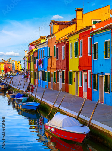 Burano island in Venice, Veneto region, Italy picturesque over canal with boats among old colourful houses stone streets