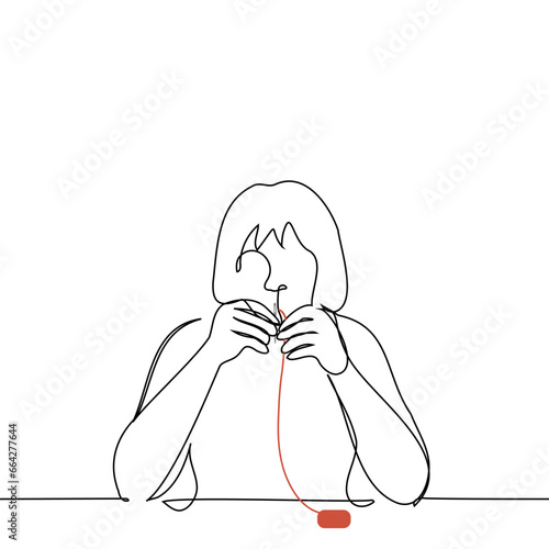 woman sitting at the table threads the eye of a needle - one line art vector. concept of sewing by hand or embroidering