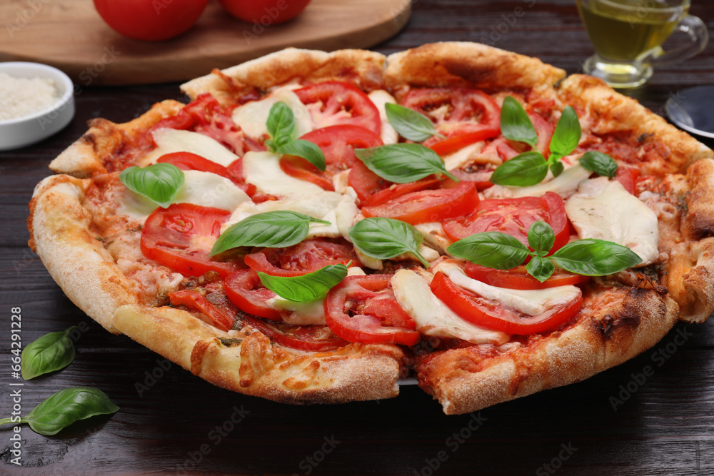Delicious Caprese pizza on black wooden table, closeup Delicious Caprese pizza on black wooden table, closeup
