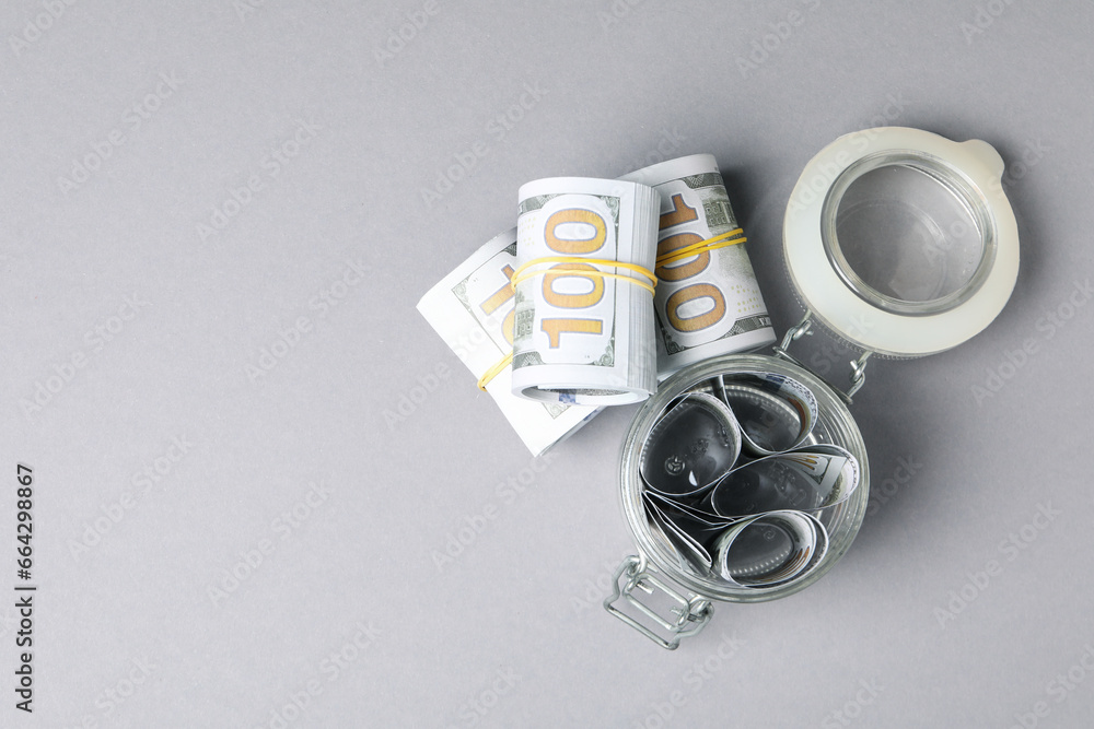 Money in a transparent jar, on a gray background. Money in a transparent jar, on a gray background.