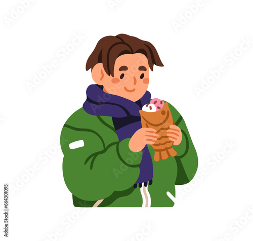 Kid eating bungeoppang, fish-shaped bread. Happy child with Korean dessert, s...