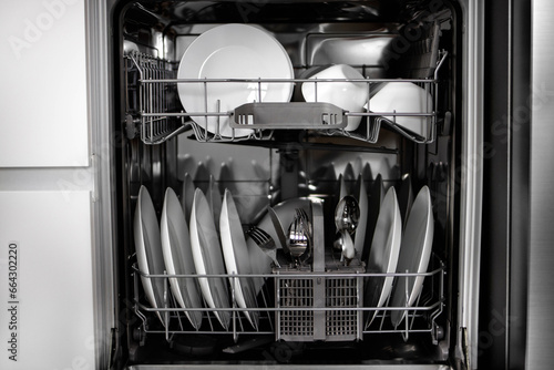 Built-in dishwasher. Clean dishes in the dishwasher. A clean white utensil. Modern technologies in the kitchen. Modern home kitchen. Housework