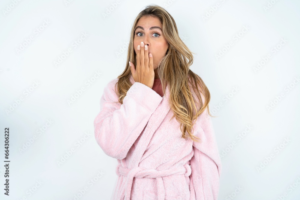 Young beautiful woman covers mouth and looks with wonder at camera, cannot believe unexpected rumors. Young beautiful woman covers mouth and looks with wonder at camera, cannot believe unexpected rumors.